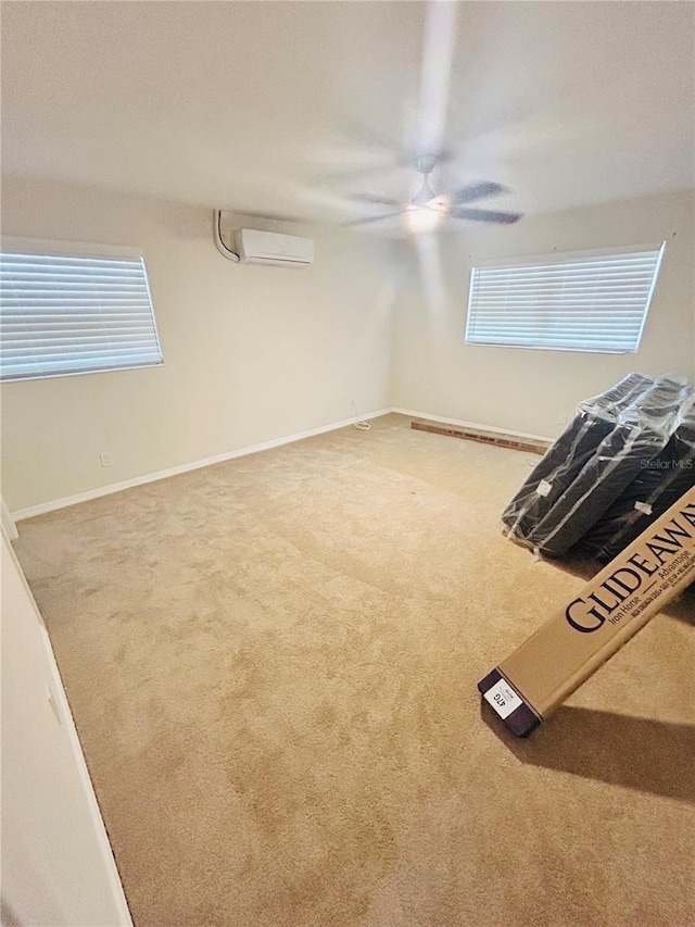 spare room featuring a wall mounted AC, ceiling fan, and carpet floors