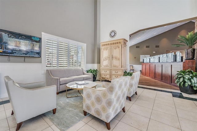 living room with a high ceiling and light tile patterned floors