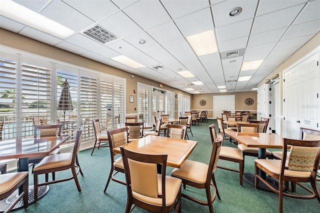 dining area featuring a paneled ceiling and carpet floors