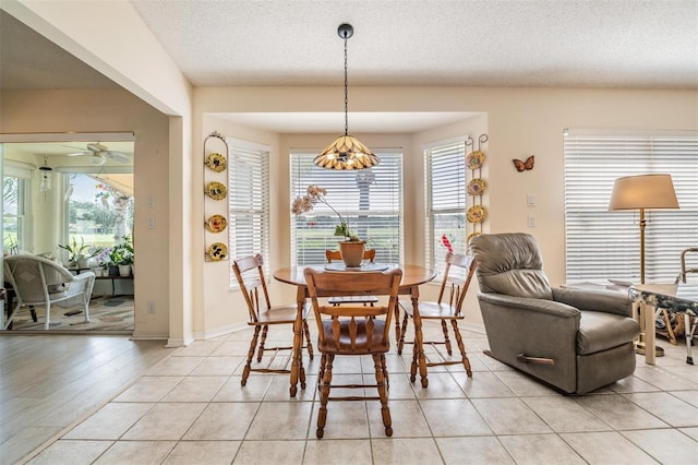 tiled dining space featuring a textured ceiling