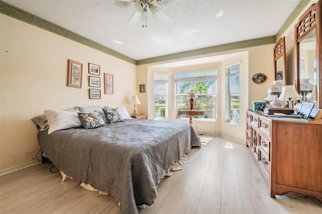 bedroom featuring a textured ceiling, light hardwood / wood-style flooring, and ceiling fan