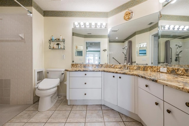 bathroom with a shower with shower door, tile patterned floors, vanity, and toilet