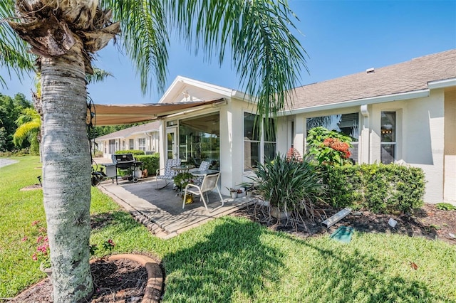 rear view of property with a lawn and a patio