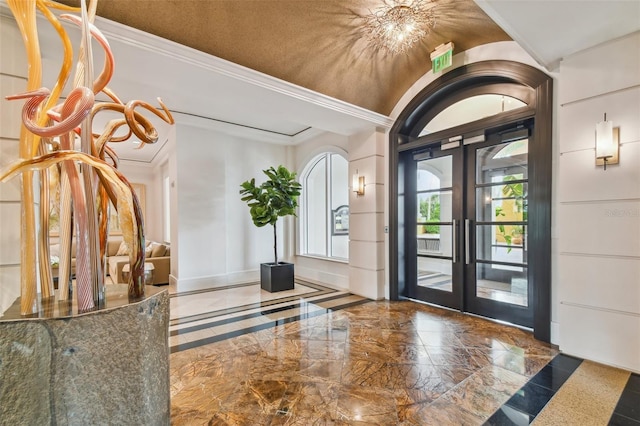 foyer with ornamental molding and french doors