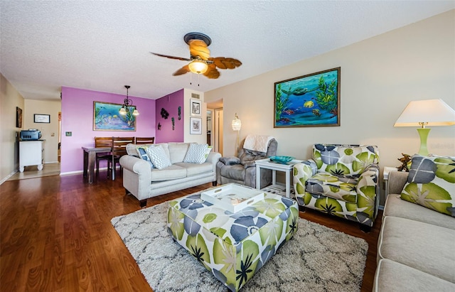 living room featuring ceiling fan, dark hardwood / wood-style flooring, and a textured ceiling