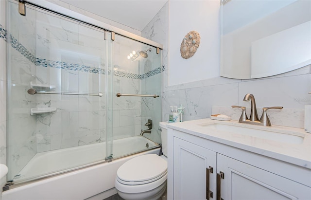 full bathroom featuring vanity, toilet, tile walls, and bath / shower combo with glass door