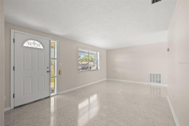 foyer entrance with a textured ceiling