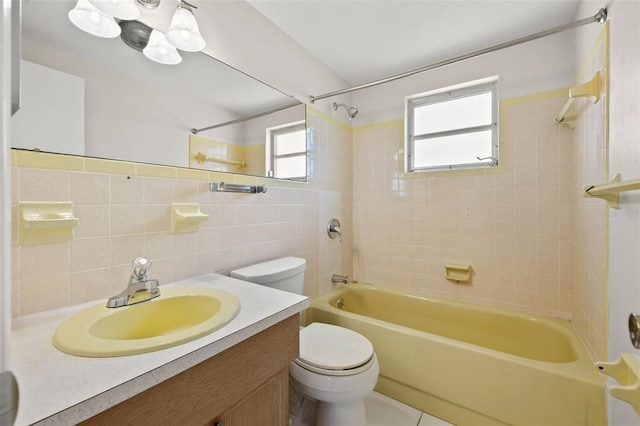 full bathroom featuring tiled shower / bath, toilet, vanity, tile walls, and decorative backsplash