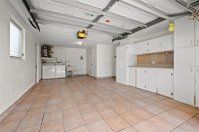 garage with water heater, washing machine and dryer, and a garage door opener