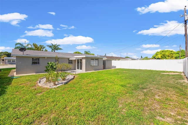 rear view of property featuring a lawn