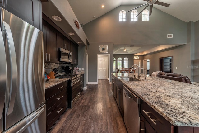 kitchen with appliances with stainless steel finishes, dark brown cabinets, ceiling fan, sink, and lofted ceiling