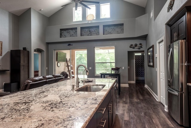 kitchen featuring stainless steel fridge, high vaulted ceiling, dark wood-type flooring, and sink