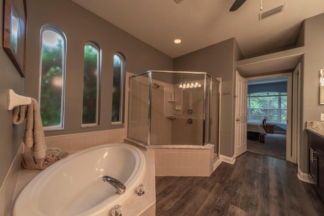 bathroom with vanity, a textured ceiling, wood-type flooring, independent shower and bath, and lofted ceiling