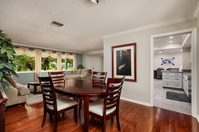 dining space with dark hardwood / wood-style flooring, crown molding, and a textured ceiling