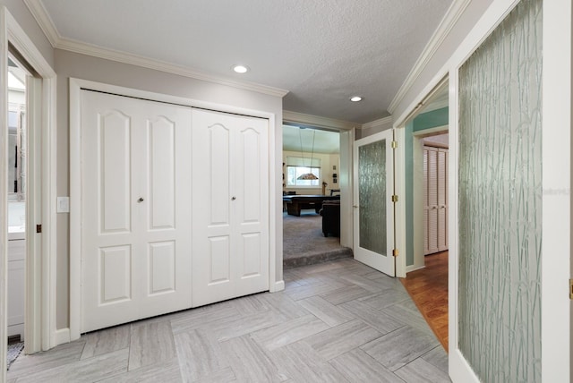 corridor featuring a textured ceiling, light parquet flooring, and crown molding