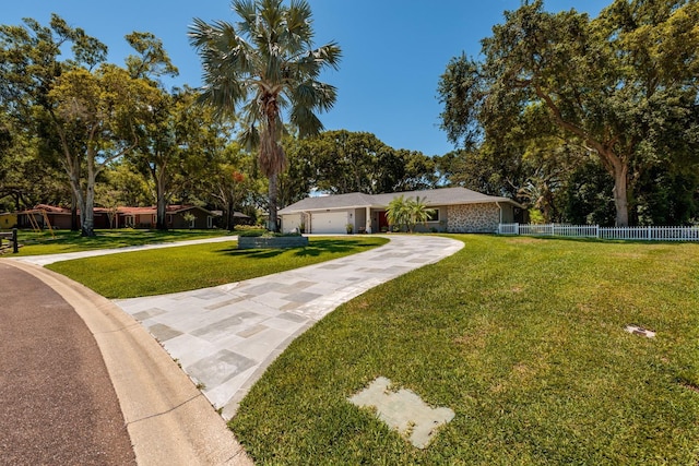 ranch-style home with a garage and a front lawn