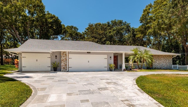 ranch-style home with a garage and a front lawn