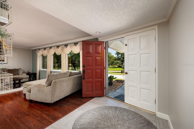 entrance foyer featuring hardwood / wood-style flooring, plenty of natural light, ornamental molding, and a textured ceiling