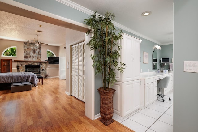 hallway featuring sink, crown molding, a textured ceiling, and light hardwood / wood-style flooring