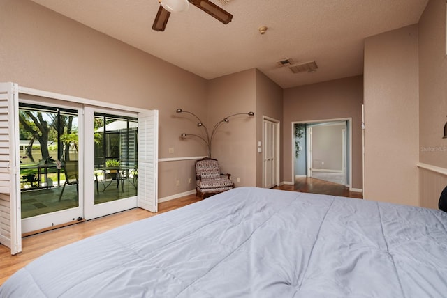 bedroom featuring a textured ceiling, access to outside, ceiling fan, and hardwood / wood-style flooring