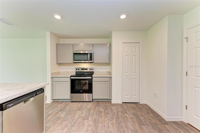 kitchen featuring stainless steel appliances, gray cabinets, and light hardwood / wood-style floors