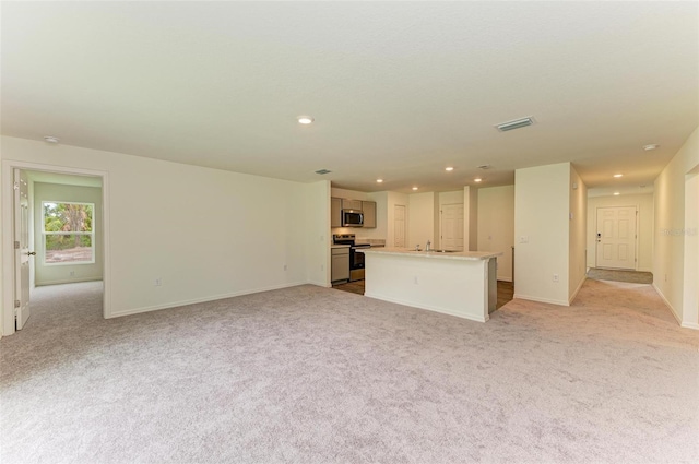 unfurnished living room featuring light colored carpet and sink