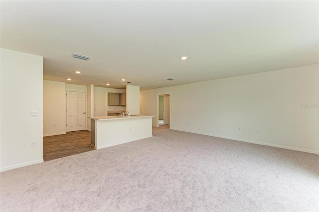 unfurnished living room featuring light carpet