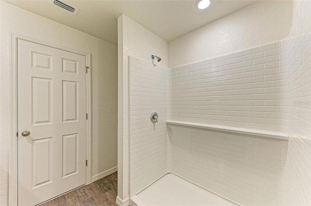 bathroom featuring hardwood / wood-style floors and tiled shower