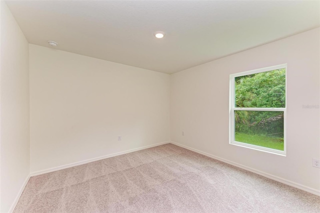 carpeted spare room featuring plenty of natural light