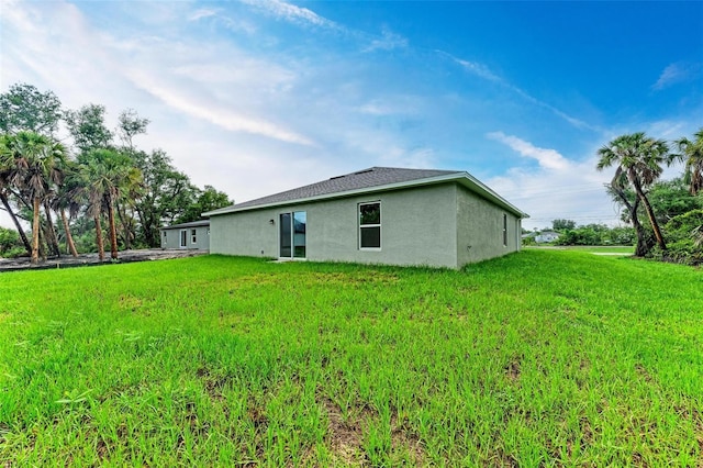 rear view of property with a yard