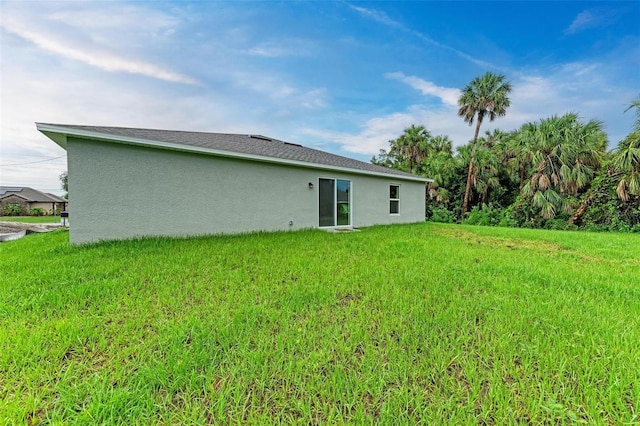 rear view of house featuring a lawn