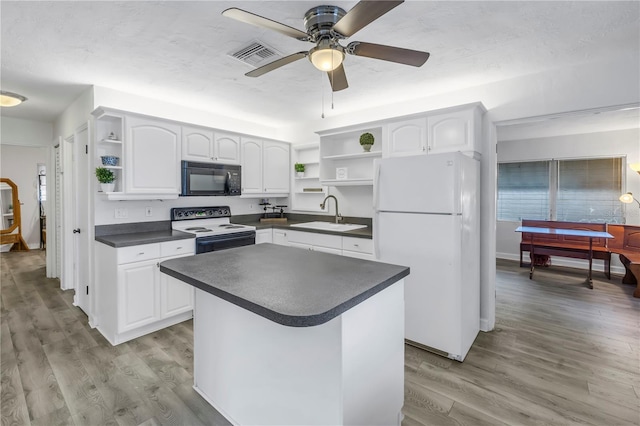 kitchen featuring sink, white cabinetry, electric range oven, white refrigerator, and light hardwood / wood-style floors