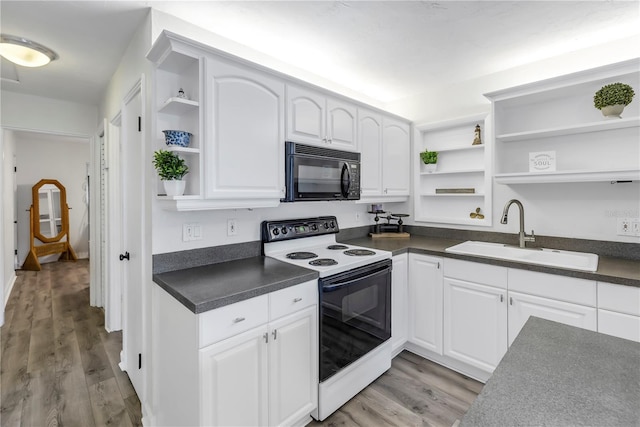 kitchen with light hardwood / wood-style floors, sink, electric range oven, and white cabinets