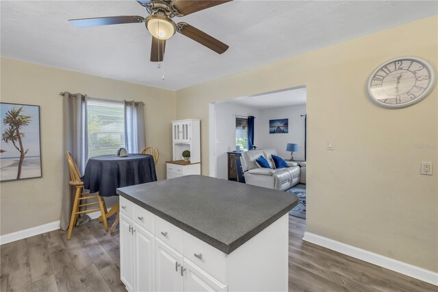 kitchen featuring wood-type flooring, white cabinets, and ceiling fan