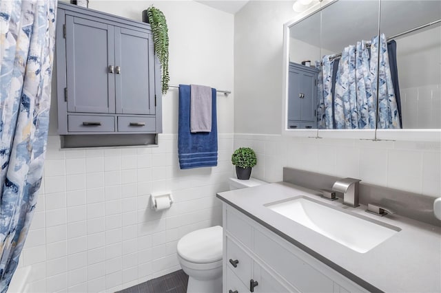 bathroom featuring a shower with curtain, vanity, toilet, and tile walls