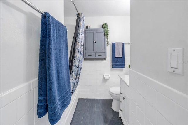 full bathroom featuring tile walls, vanity, toilet, shower / bathtub combination with curtain, and tile patterned floors