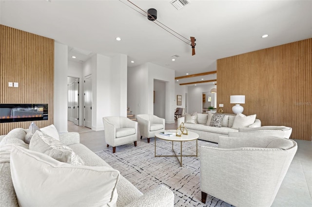 living room featuring a large fireplace and wooden walls