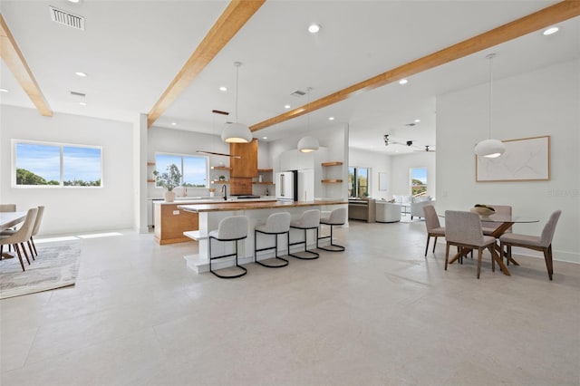 kitchen featuring high end fridge, a breakfast bar, ceiling fan, pendant lighting, and a kitchen island