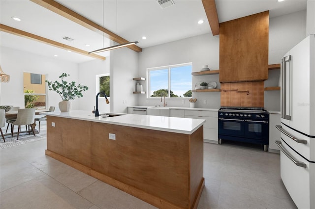 kitchen featuring sink, white cabinets, beamed ceiling, and high end appliances