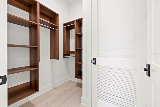 walk in closet with light wood-type flooring