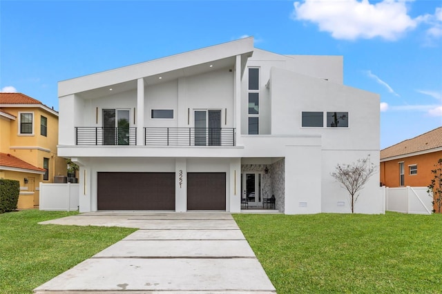 view of front facade featuring a garage, a balcony, and a front yard