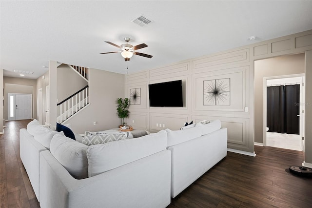 living room with dark hardwood / wood-style flooring and ceiling fan