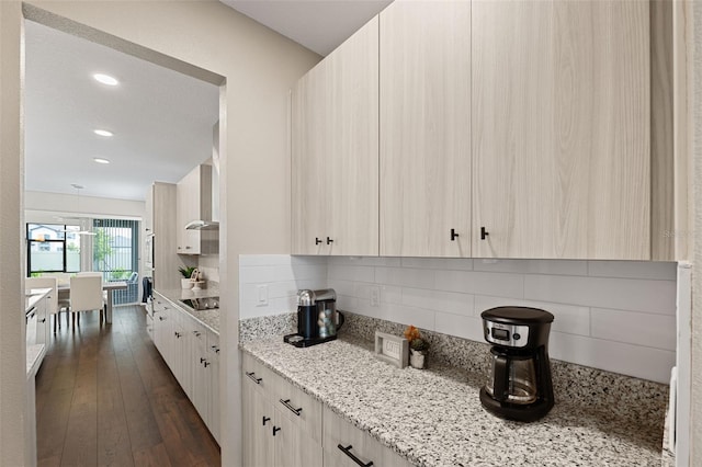 kitchen with backsplash, black electric stovetop, dark hardwood / wood-style floors, light stone countertops, and light brown cabinetry