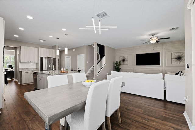 dining room with a textured ceiling, dark hardwood / wood-style flooring, ceiling fan, and sink