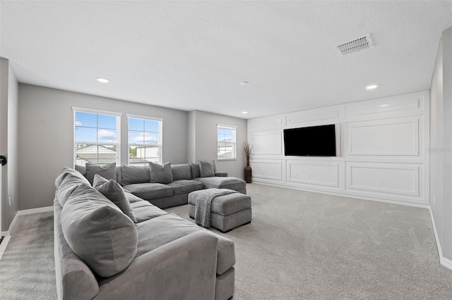 living room with a textured ceiling and light carpet