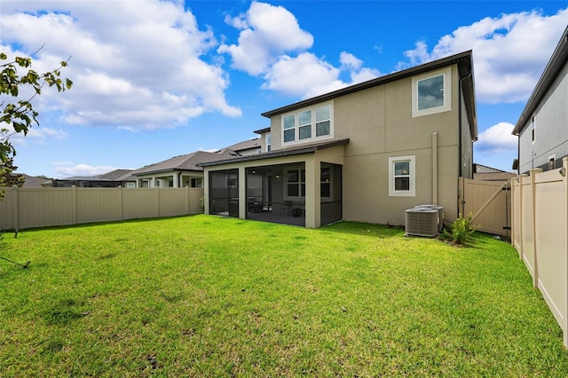 back of property with a sunroom, central AC unit, and a yard