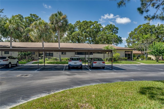 view of vehicle parking with a carport and a yard