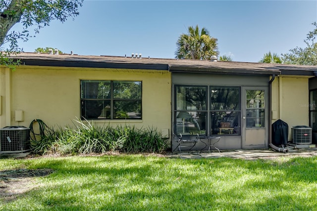 rear view of house with a yard and central AC