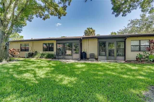 back of property with a lawn and central air condition unit