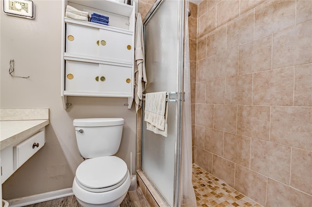 bathroom featuring vanity, toilet, and a shower with door